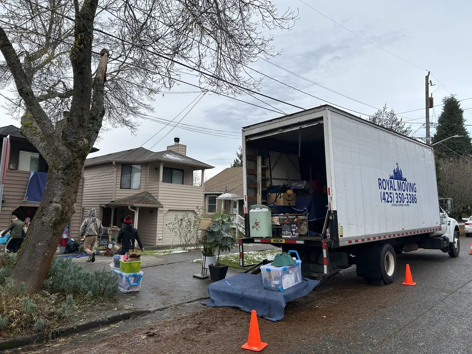 The crew carrying boxes to the truck on a residential street