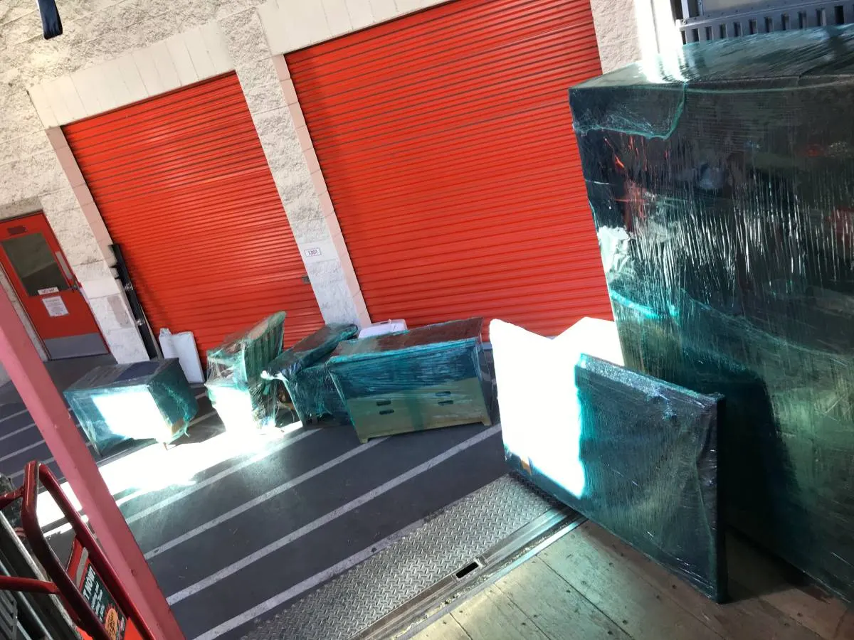 Wrapped furniture on a cart in front of storage units