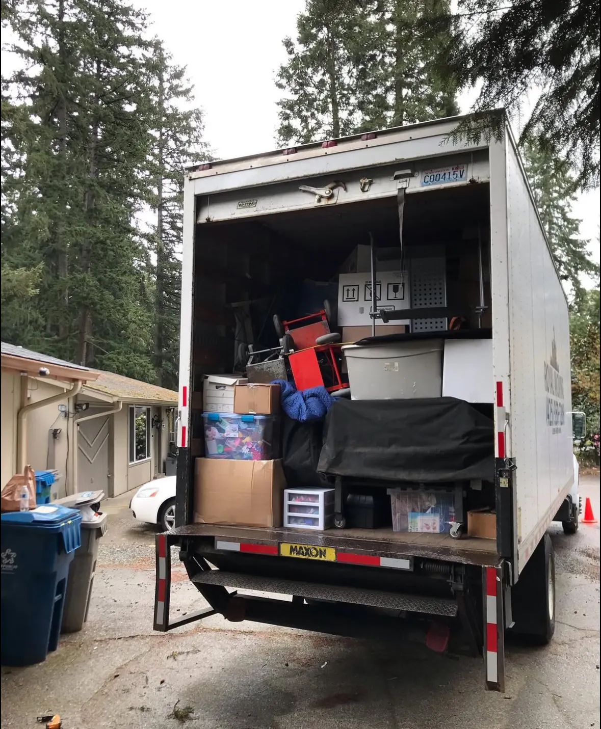The back of the truck loaded to the door with boxes and furniture