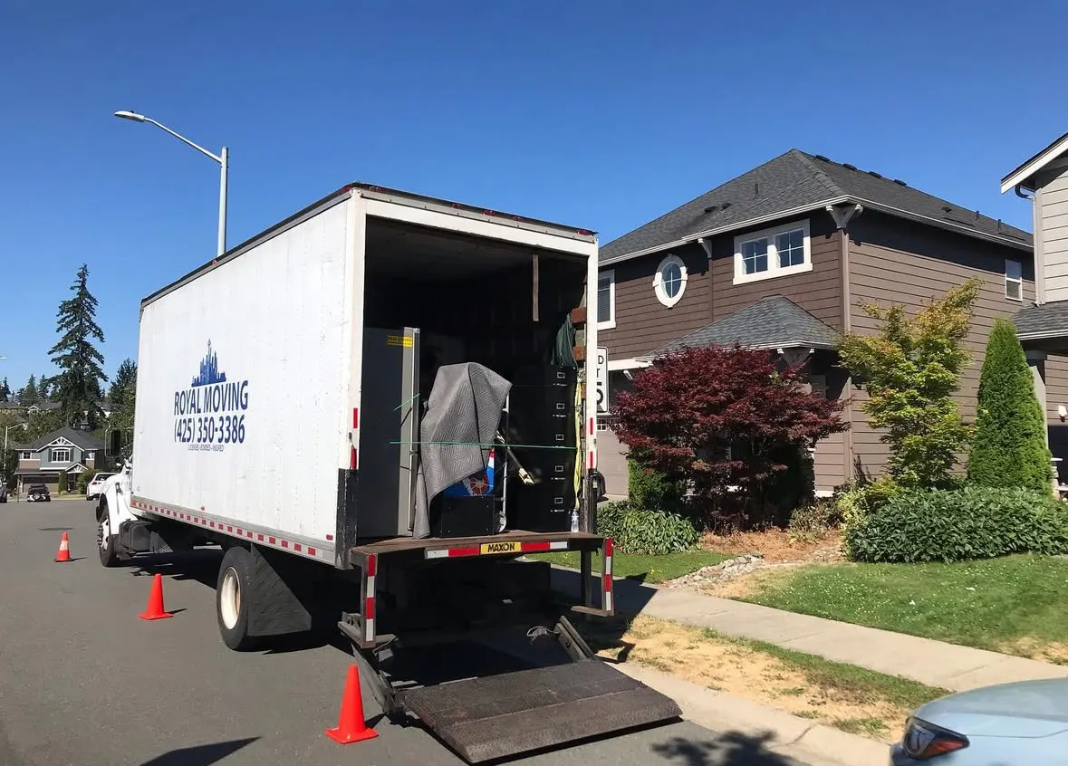 The truck with its ramp down at a house on a sunny day